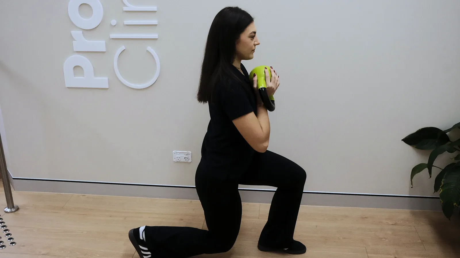 Practitioner demonstrating a weighted lunge in the rehab space