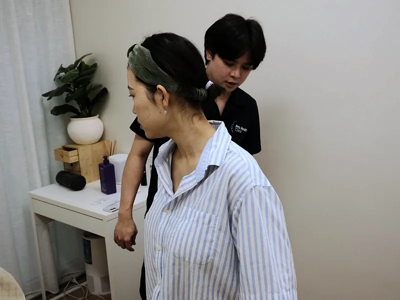 Chiropractor talking a patient through a postural assessment
