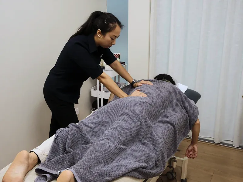 Remedial massage therapist working on a patient’s upper back